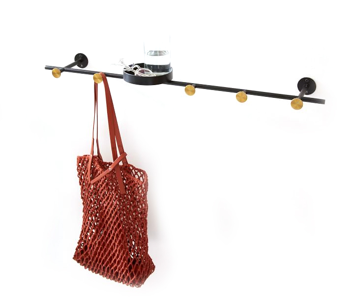 A horizontal wall-mounted coat rack with a purse hanging from it.